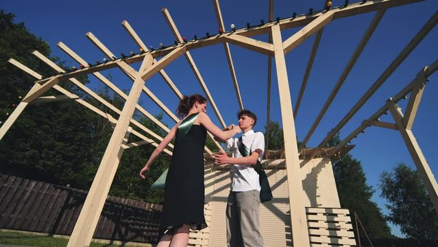 Graduating boyfriend and girlfriend dancing the school waltz in the street.