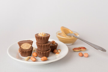 Tasty chocolate peanut butter cups on color background