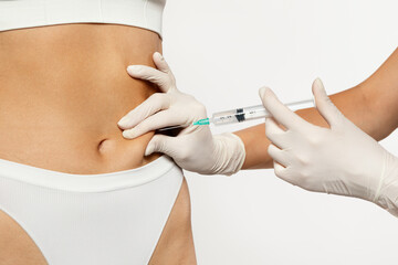 A gloved medical professional is carefully administering subcutaneous injection in abdomen - obrazy, fototapety, plakaty