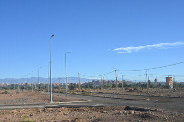 Neubaugebiet in Ouarzazate in Marokko, Straßen und Laternen stehen schon, es fehlen nur nich die Häuser, 