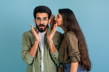 Long-haired indian woman whispering her boyfriend rumors