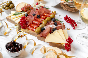 Party charcuterie board prosciutto ham, salami and cheese appetizers served in the shape of a Christmas tree. party food for New Year's Eve, Christmas or birthday