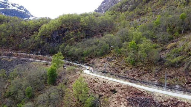 Three Yellow Vans Crossing the Flåmsbana Train Tracks to Flåm - Norway 2.7K Aerial Footage