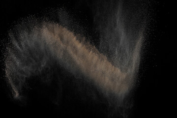 Soil explosion on black background. Abstract texture. Cloud of brown ground. Sand explode.