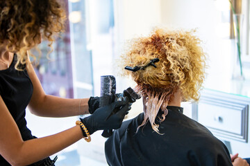 Professional stylist working on a client's curly hair