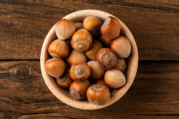 Overhead shot of hazelnuts in bowl on wooden table. Healthy snacks