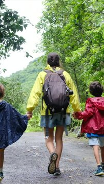 vibrant adventure with an adventurous mom and her backpack-toting kids, draped in lively raincoats, as they explore mesmerizing jungles. Immerse yourself in the enchanting world of travel, discovery, 