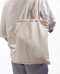 Carrying modern eco tote bag on shoulder. Woman with shopper