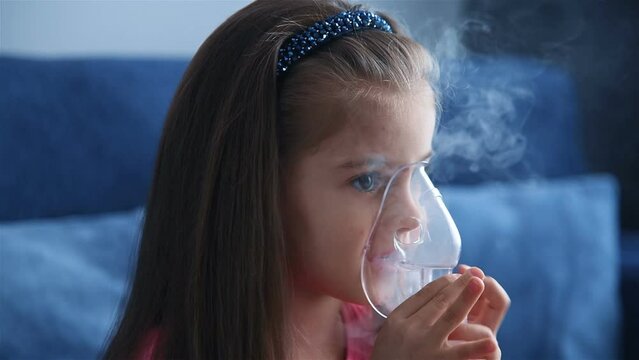Portrait of child in an inhalation mask. Children's lung health concept. Slow Motion Effect.