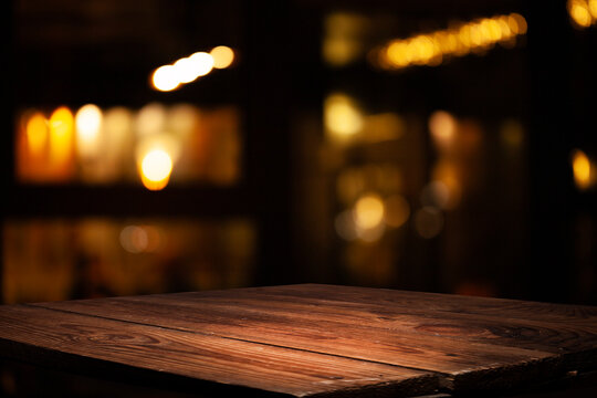 Empty dark wooden table in front of restaurant abstract blurred bokeh background. can be used to demonstrate or mount your products. Layout for space