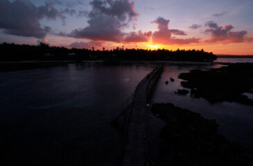 Beautiful landscape. Sunset on the seashore. Wooden bridge on Cloud 9 beach, Siargao Island Philippines.