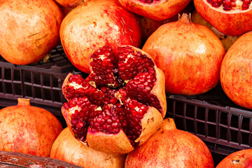Fresh raw organic pomegranate pile texture background. Ruby natural pomegranate heap close up