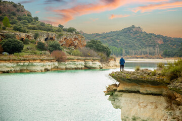 Person alone contemplating the lake from a cliff and enjoying nature in the lagoons of Ruidera