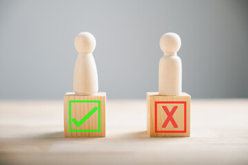 People demonstrate right and wrong on wooden blocks contemplating yes or no. Business dilemma shown...