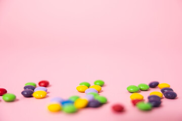Obraz premium A pink web background with colorful chocolate candies perfect for a party, birthday or Valentines's day