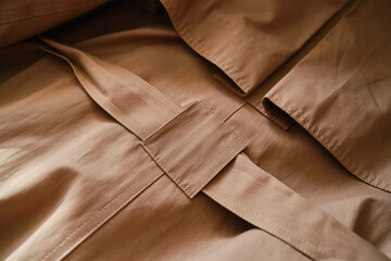Close up of fashion details of autumn brown trench coat with strap. Women's street style