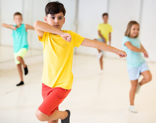 Group children learn dance movements in dance class