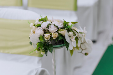 A wedding bouquet of beautiful white roses stands on the table in a vase. Photography, nature.