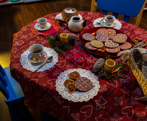 Table with red cloth and objects ready for tea party at kindergarten