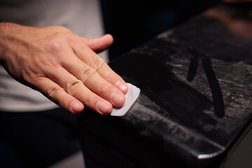 caucasian hand with dust on finger tips after touching black dusty surface, closeup with selective...