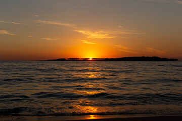 Beach sunset in Uruguay with orange sky and waves summer