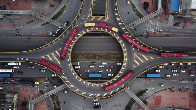 Aerial drone shot of Roundabouts in Bogota, Colombia, Latin America. Traffic in Bogota, Transmilenio. Dedicated busway on the top level. Famous roundabout full of red buses. High quality 4k footage.