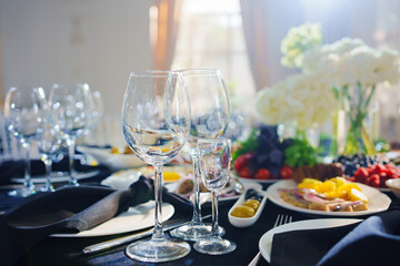 Beautifully set banquet table. Snacks, flowers and wine glasses.