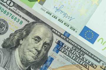 Close-up image of hundred dollar and hundred euro bills.
Banknotes of 100 US dollars and 100 euros.
Currency exchange rate. 