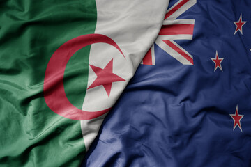 big waving national colorful flag of new zealand and national flag of algeria .