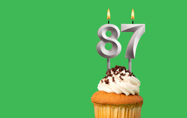 Birthday card with candle number 87 - Cupcake on green background
