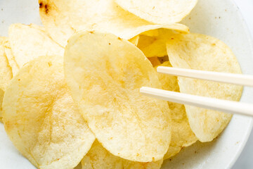 ポテトチップスを箸で食べる。
