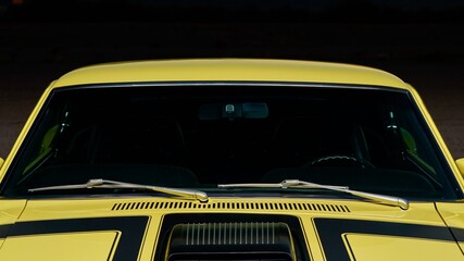 Hood of a car yellow car with black racing stripes