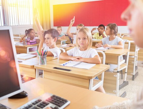 Portrait of diligent towheaded preteen girl looking at camera during lesson in primary school