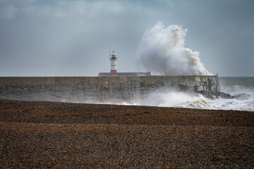 Fototapeta na wymiar Stormy weather in Newhaven, East Sussex, England in autumn. View of the jetty and the lighthouse.
