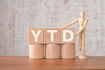 There is wood cube with the word YTD. It is an abbreviation for Year to date as eye-catching image.