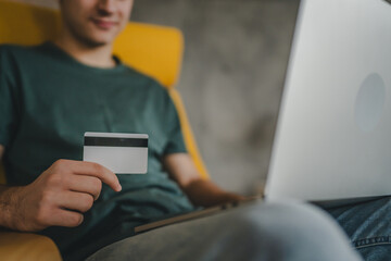 teenager young man at home use credit card shopping online e-banking