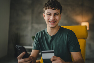 teenager young man at home use credit card shopping online e-banking