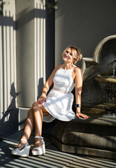 A beautiful woman In a white dress  in the sunlight