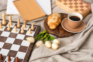 Chess board with breakfast and tulips on plaid