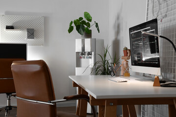 Programmer's workplace with computer monitor and glowing lamp in office