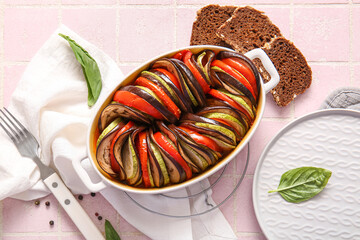 Baking dish of tasty Ratatouille on pink tile background