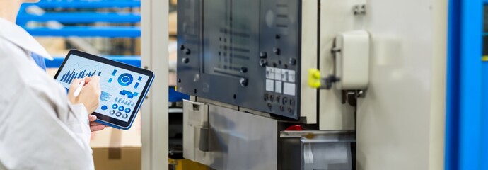 Engineer operating a machine tool with a tablet