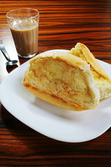 Grilled bread with glass of latte on the wooden table.