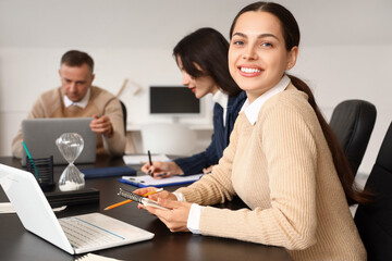 Young businesswoman working at table in office