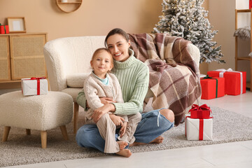 Happy mother with her little daughter at home on Christmas eve