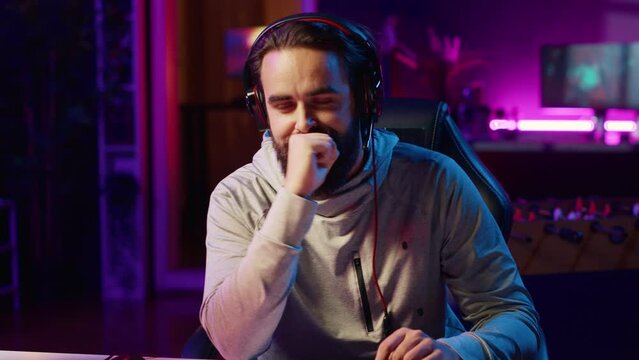 Cheerful gamer unaffected by losing match with teammates while playing competitive esports tournament. Man being optimistic in spite of loss while enjoying multiplayer videogame with friends