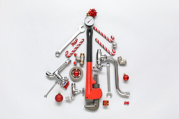 Christmas tree made of plumber's items and decorations on light background