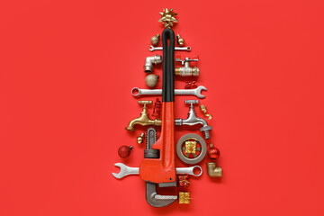Christmas tree made of plumber's items and decorations on red background