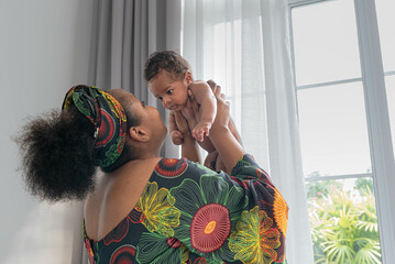 An African mother holding her son is 2-month-old baby newborn, with love and happy. concept to African family relationship and black baby newborn.