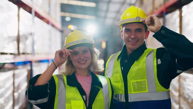 Young man and woman happy standing and looking at camera. Male and female warehouse worker smiley and smart confident at storehouse